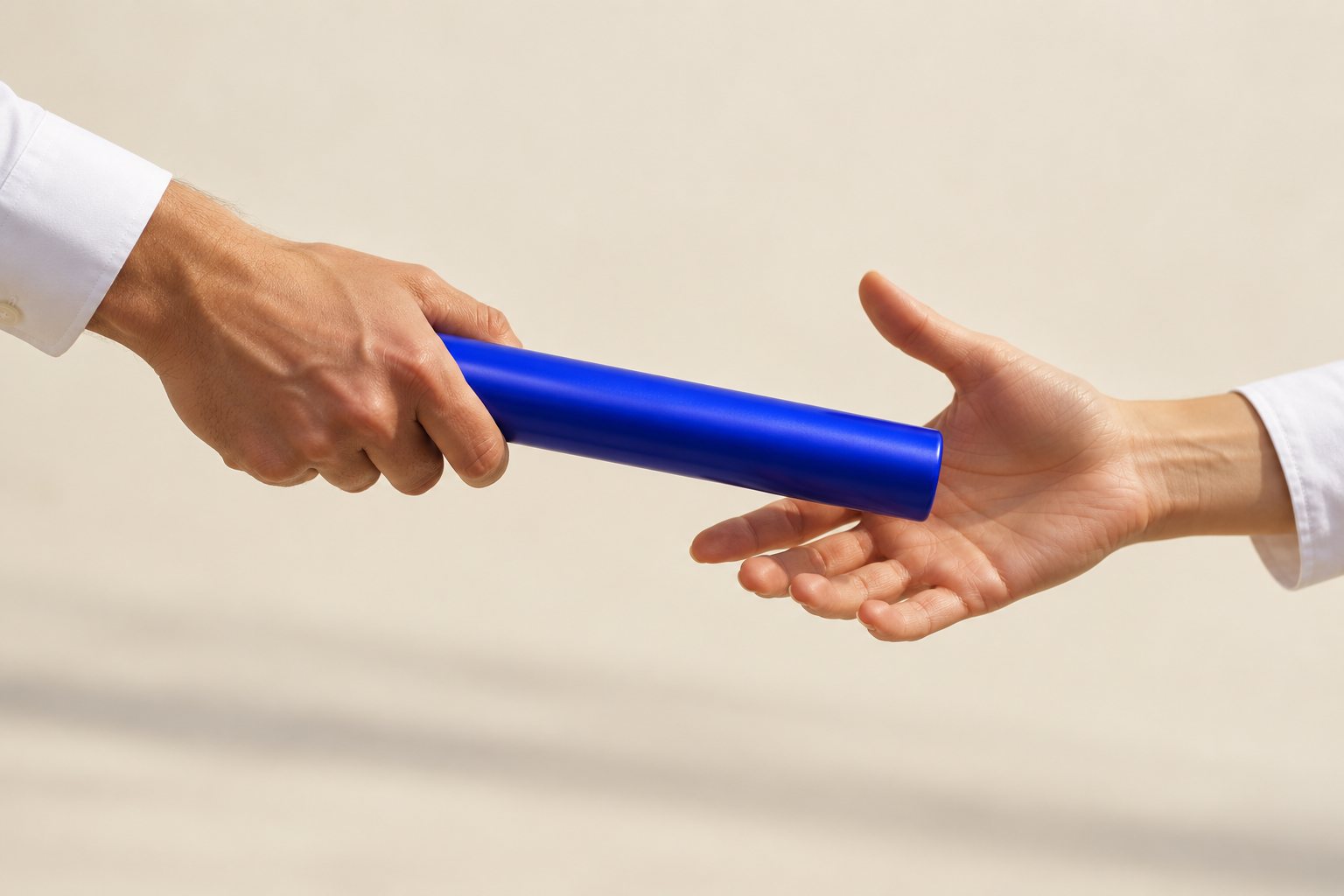 One hand passing a blue baton into another hand